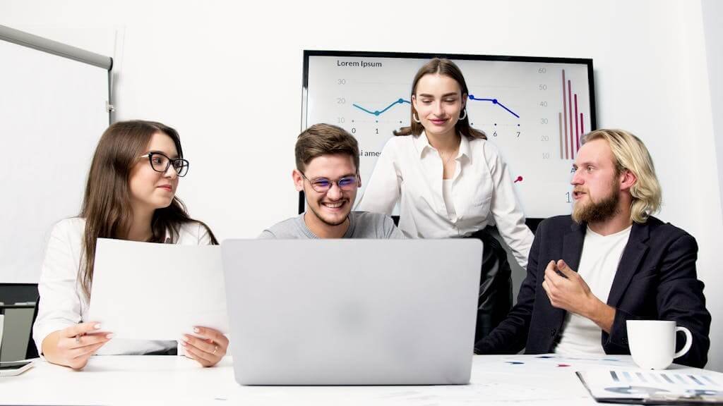 2 Women and Man Sitting Beside Table With Laptop Computers